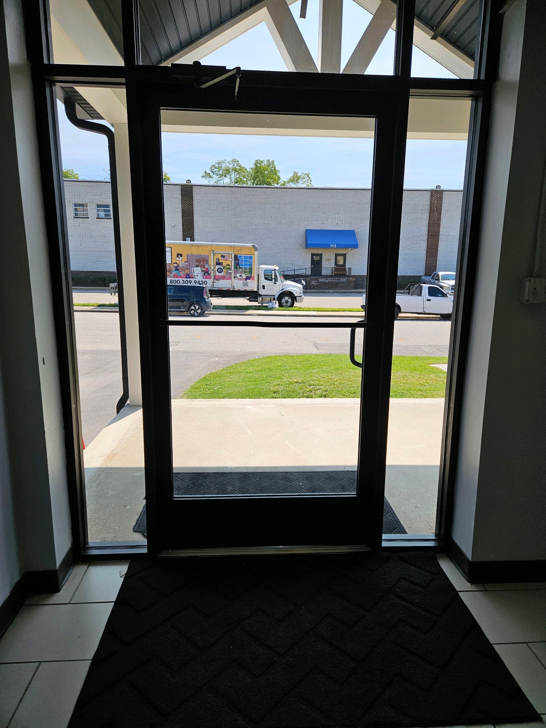 Interior view of commercial glass entrance door with full frame, installed in a Maryland office storefront by Recommended Locksmith
