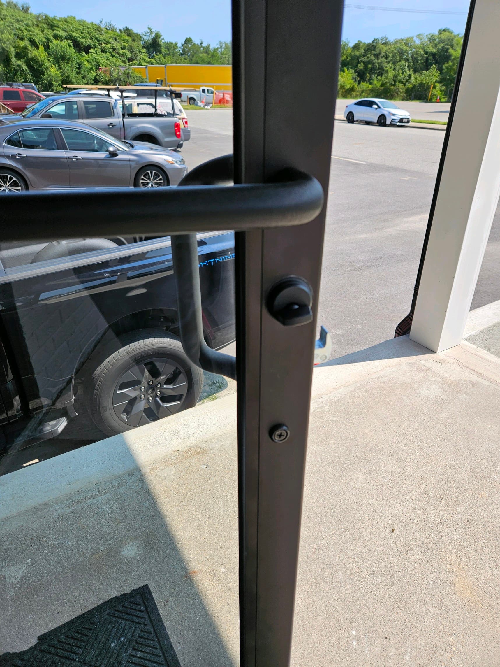 Commercial storefront door with matte black thumb-turn deadbolt and lever handle, installed by Recommended Locksmith in Maryland